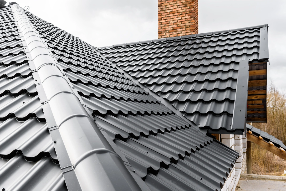 new black shingles on a home roof with a brick chimney
