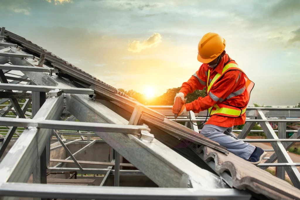 roof technician installing a roof with a sunset background