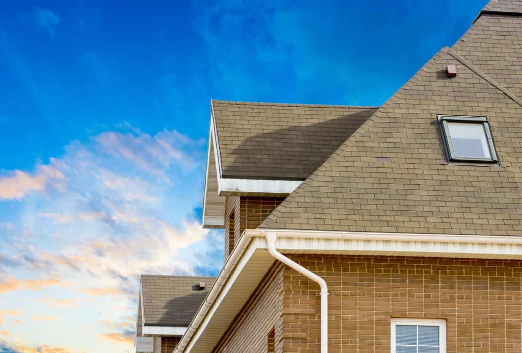roofing on a brick home with a blue sky background