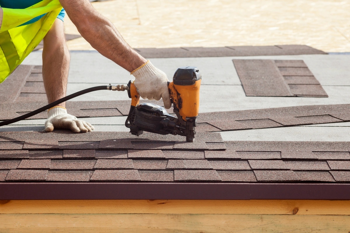 roofing materials being installed on a roof by a roof tech with power tools